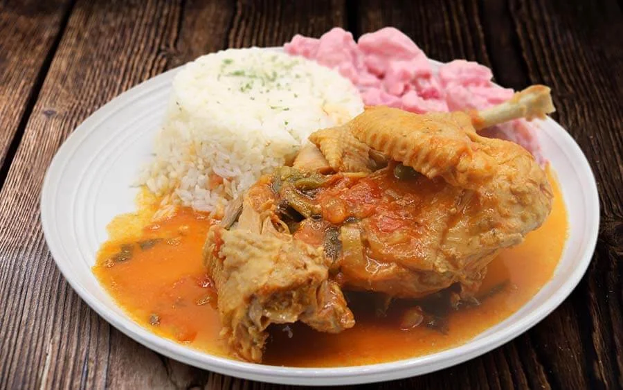 Chicken in sauce with white rice and pink salad 
