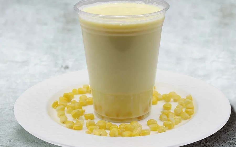 White juice on a white plate and corn 