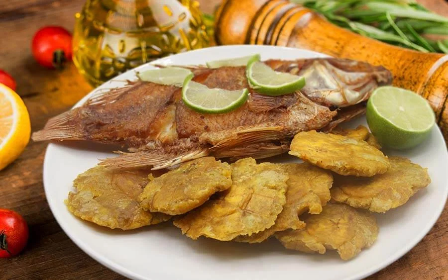Fried fish with sliced lemons and fried plantain 